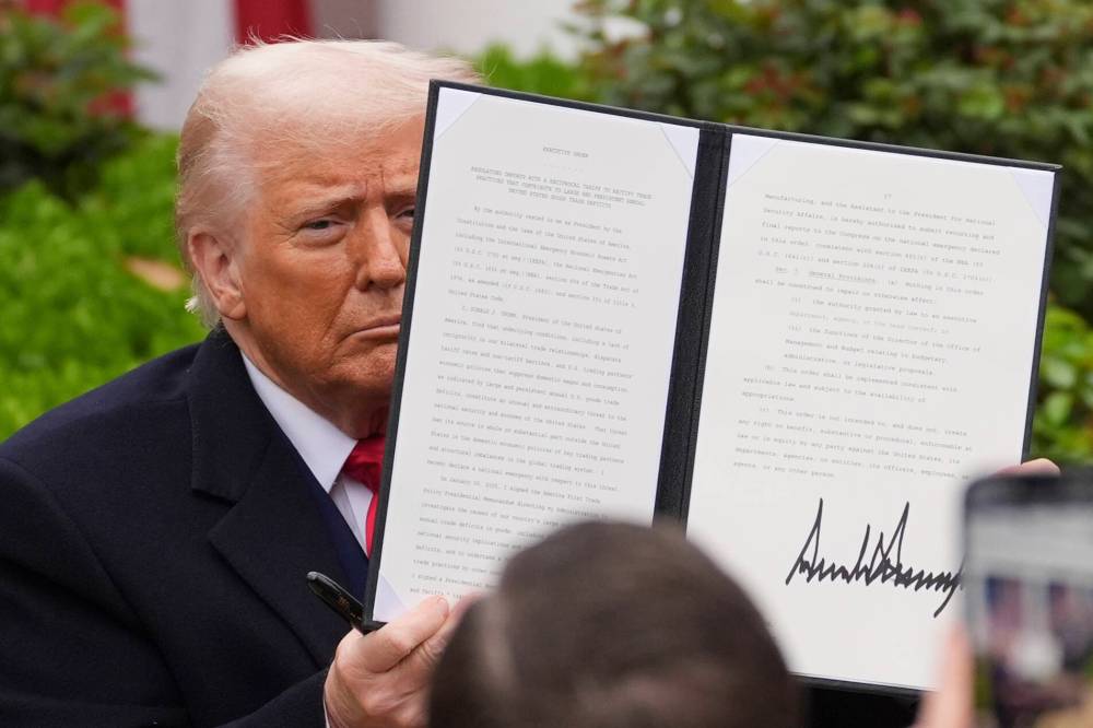 EVAN VUCCI / THE ASSOCIATED PRESS
U.S. President Donald Trump holds a signed executive order during an event to announce new tariffs Wednesday.