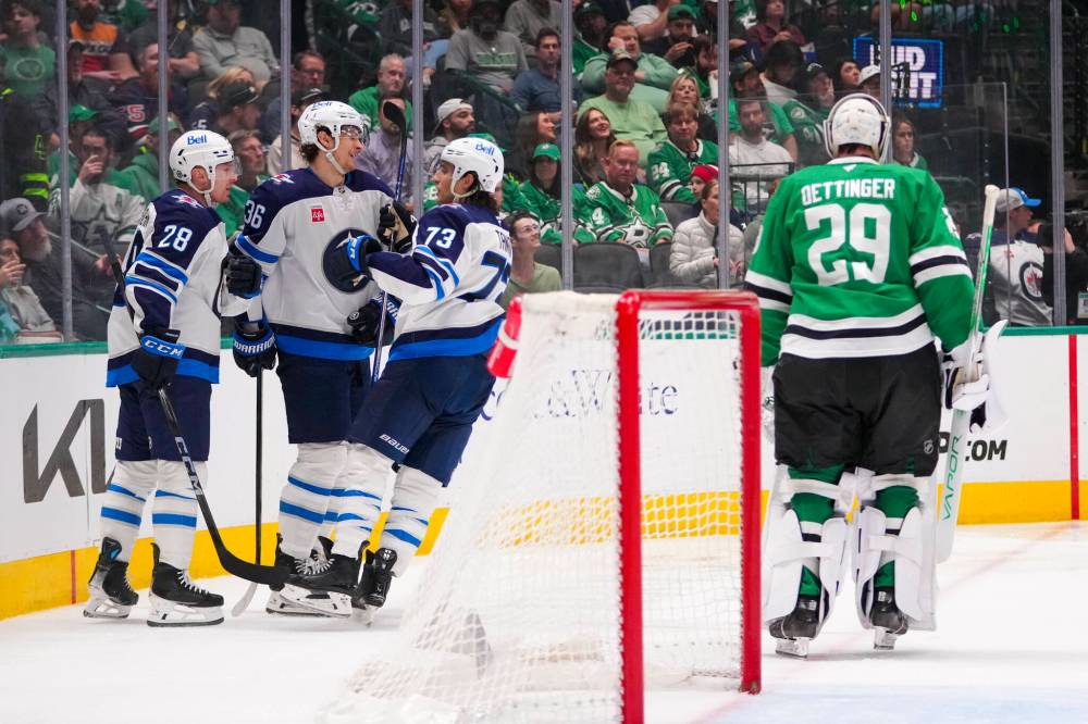 Julio Cortez / The Associated Press
Dallas Stars goaltender Jake Oettinger skates near his crease as Winnipeg Jets players, from left, Jaret Anderson-Dolan, Morgan Barron and Brandon Tanev celebrate a second period goal by Barron in the first period.