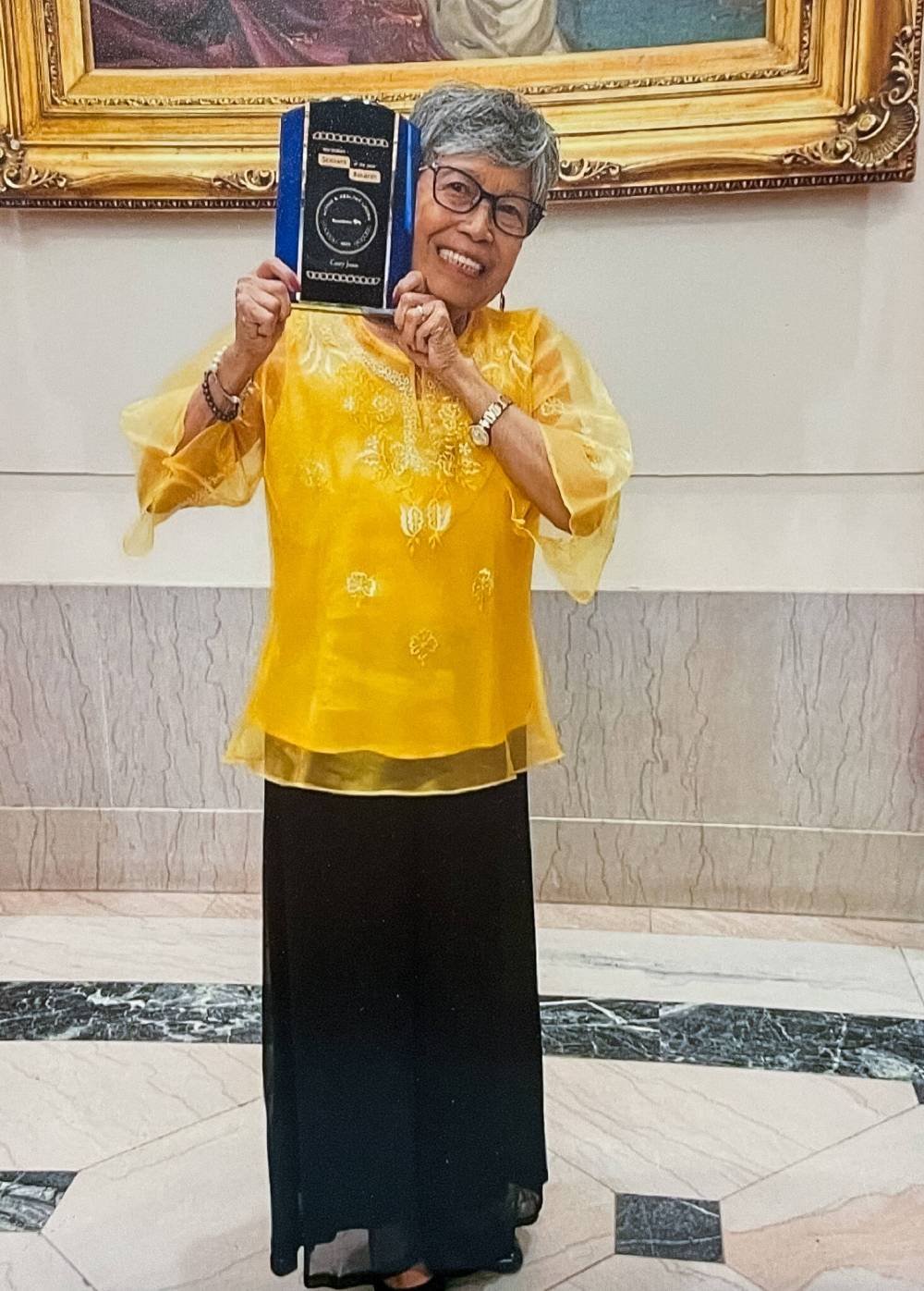 Supplied
Socorro ‘Cory’ Juan holds up one of the many awards she received for community service.