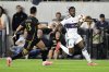 Vancouver Whitecaps defender Sam Adekugbe, right, controls the ball against Los Angeles FC forward Cristian Olivera (13) during the first half of the first soccer match of an MLS Cup playoffs opening round in Los Angeles, Sunday, Oct. 27, 2024. (AP Photo/Alex Gallardo)