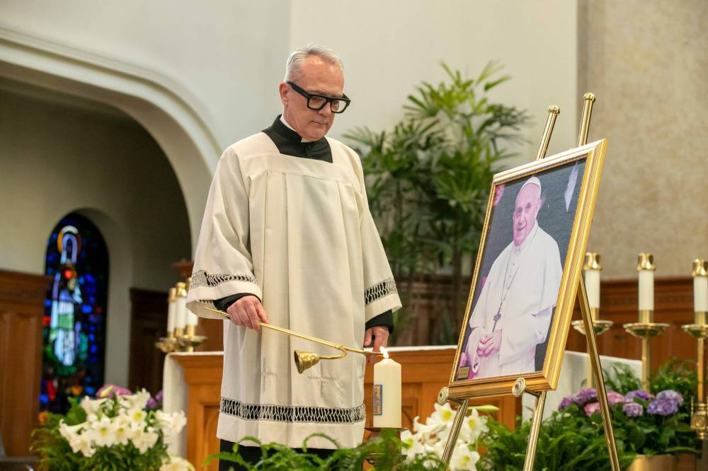 BROOK JONES / FREE PRESS
Rev. Darren Gurr of St. Gianna Beretta Molla Roman Catholic Church lights a candle that bears the coat of arms of Pope Francis at a memorial mass for the late pontiff at St. Mary’s Cathedral Wednesday.