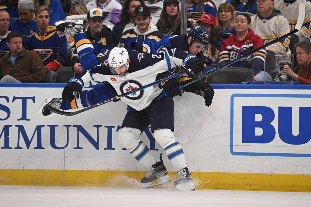 Connor Hamilton / THE ASSOCIATED PRESS
Winnipeg Jets’ Dylan DeMelo (2) lays a check on check the Blues’ Radek Faksa on Sunday in St. Louis.