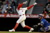 Los Angeles Angels' Taylor Ward (3) hits a two-run home run next to Toronto Blue Jays catcher Alejandro Kirk to score Zach Neto during the first inning of a baseball game in Anaheim, Calif., Tuesday, May 6, 2025. (AP Photo/Alex Gallardo)