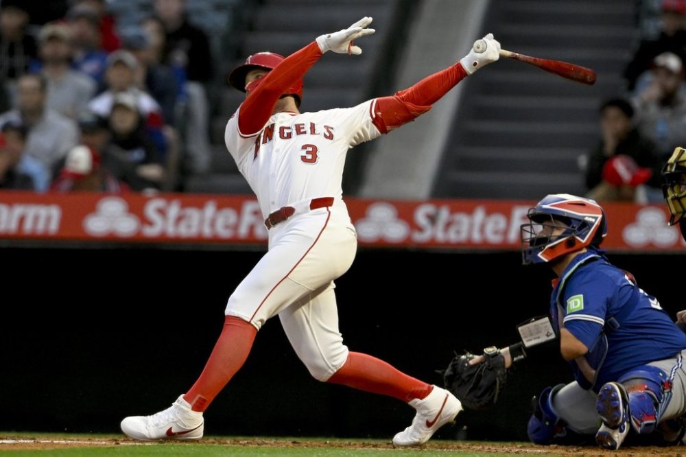 Los Angeles Angels' Taylor Ward (3) hits a two-run home run next to Toronto Blue Jays catcher Alejandro Kirk to score Zach Neto during the first inning of a baseball game in Anaheim, Calif., Tuesday, May 6, 2025. (AP Photo/Alex Gallardo)