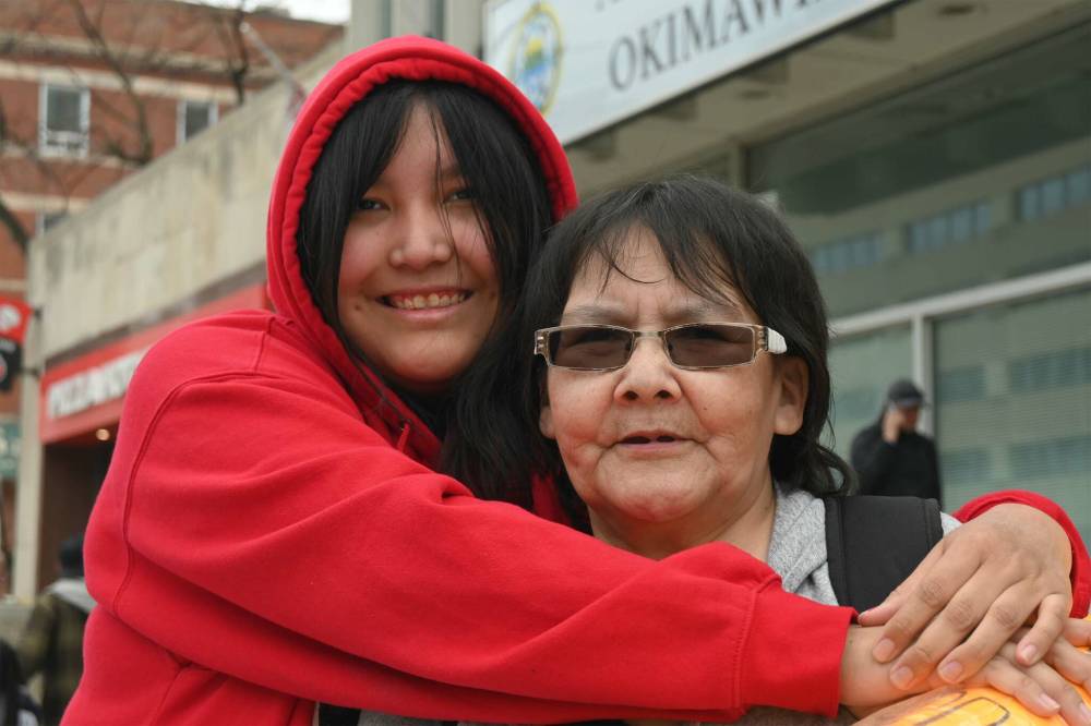 ALEX LAMBERT / FREE PRESS
Rally participant Chloe Kakepetum (left) hugs Myrna Mawakeesic, who says she developed Chronic Obstructive Pulmonary Disease because of the constant flooding her house gets every spring in Sandy Lake, Ont. The rally, in support of a lawsuit against the federal government, was at Anishininew Okimawin on Broadway.