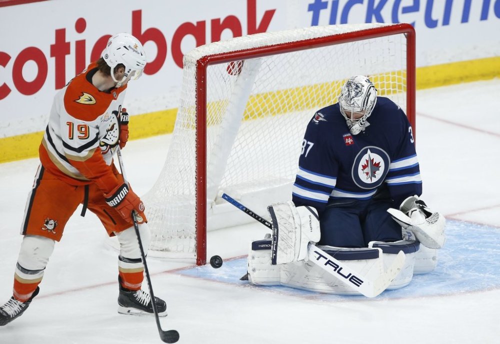 Winnipeg Jets goaltender Connor Hellebuyck (37) saves the shot from Anaheim Ducks' Troy Terry (19) during second period NHL action in Winnipeg on Wednesday, April 16, 2025. THE CANADIAN PRESS/John Woods