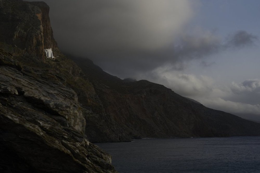 The Monastery of Panagia Hozoviotissa, carved into a cliffside high above the Aegean Sea is illuminated by the sun in Amorgos island, Greece, on Friday, March 28, 2025.(AP Photo/Petros Giannakouris)