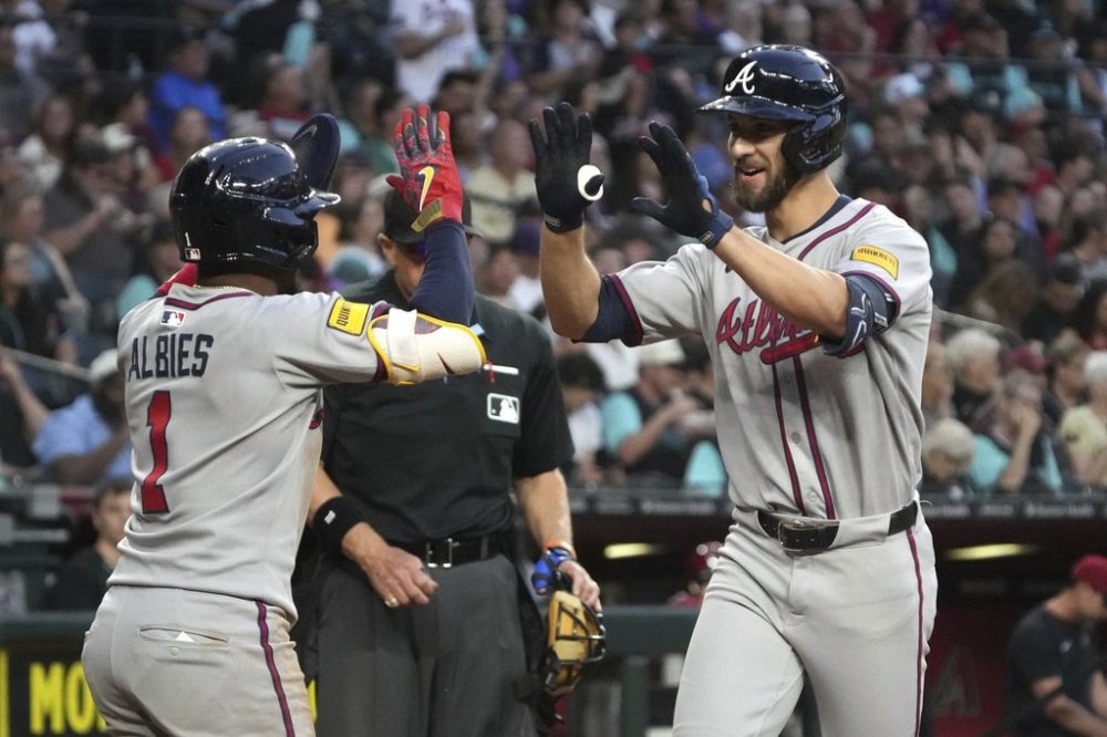 Atlanta Braves' Eli White celebrates with Ozzie Albies (1) after hitting a two run home run against the Arizona Diamondbacks in the seventh inning during a baseball game, Saturday, April 26, 2025, in Phoenix. (AP Photo/Rick Scuteri)