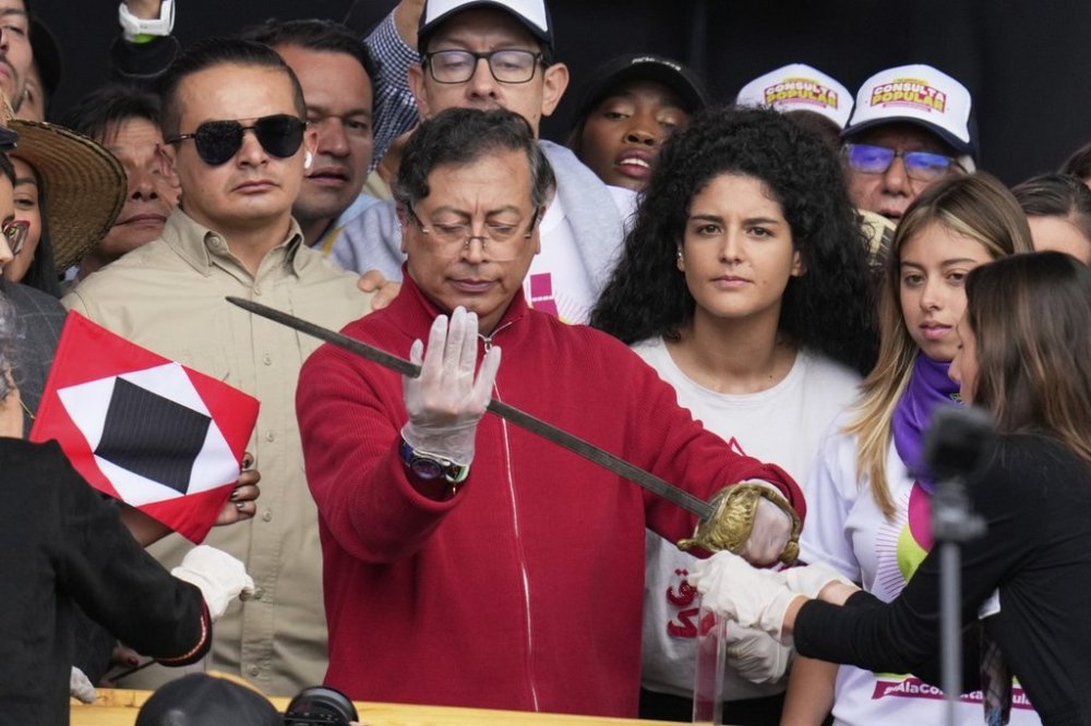 President Gustavo Petro holds a sword that once belonged to independence hero Simón Bolívar during a speech to supporters outside Congress in Bogotá, Colombia, Thursday, May 1, 2025, before presenting a referendum proposal on his labor reform to the Senate following two failed attempts in the legislature. (AP Photo/Fernando Vergara)