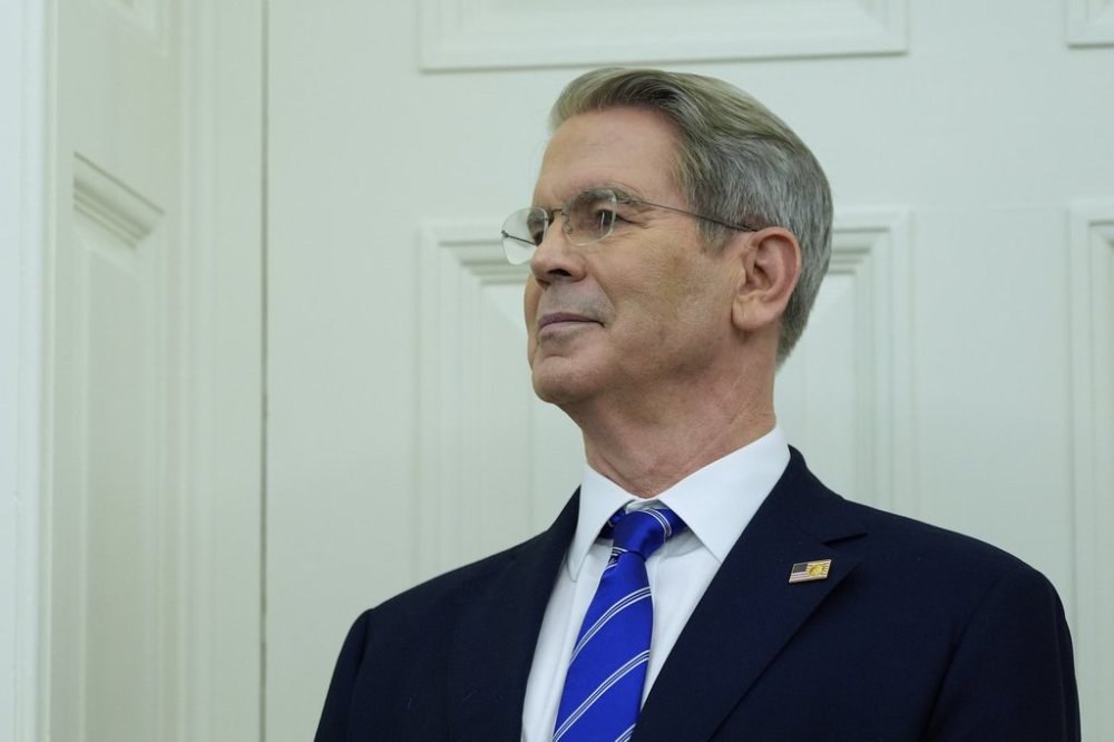 Treasury Secretary Scott Bessent listens as President Donald Trump speaks with reporters as he participates in a ceremonial swearing in of Paul Atkins as chairman of the Securities and Exchange Commission, in the Oval Office of the White House, Tuesday, April 22, 2025, in Washington. (AP Photo/Alex Brandon)