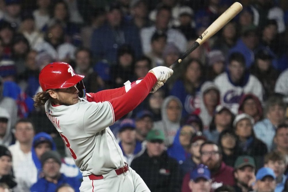 Philadelphia Phillies' Alec Bohm hits a sacrifice fly to Chicago Cubs right fielder Kyle Tucker during the 10th inning of a baseball game in Chicago, Sunday, April 27, 2025. (AP Photo/Nam Y. Huh)