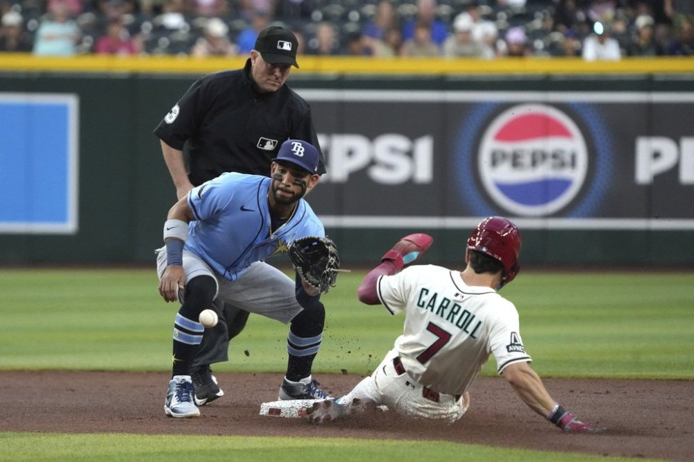 Arizona Diamondbacks' Corbin Carroll (7) steals second base under a tag by Tampa Bay Rays shortstop José Caballero, front left, in the first inning during a baseball game, Thursday, April 24, 2025, in Phoenix. (AP Photo/Rick Scuteri)