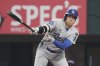 Los Angeles Dodgers' Shohei Ohtani follows through on a ground out in the first inning of a baseball game against the Texas Rangers in Arlington, Texas, Sunday, April 20, 2025. (AP Photo/Tony Gutierrez)