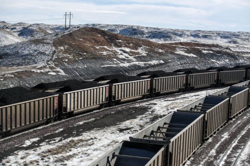 FILE - Rail cars are filled with coal and sprayed with a topper agent to suppress dust north of Douglas, Wyo,, Jan. 9, 2014. (Ryan Dorgan/Casper Star-Tribune via AP, File)