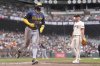 Milwaukee Brewers' Garrett Mitchell (5) scores after a wild pitch by San Francisco Giants pitcher Landen Roupp, right, during the second inning of a baseball game in San Francisco, Thursday, April 24, 2025. (AP Photo/Jeff Chiu)