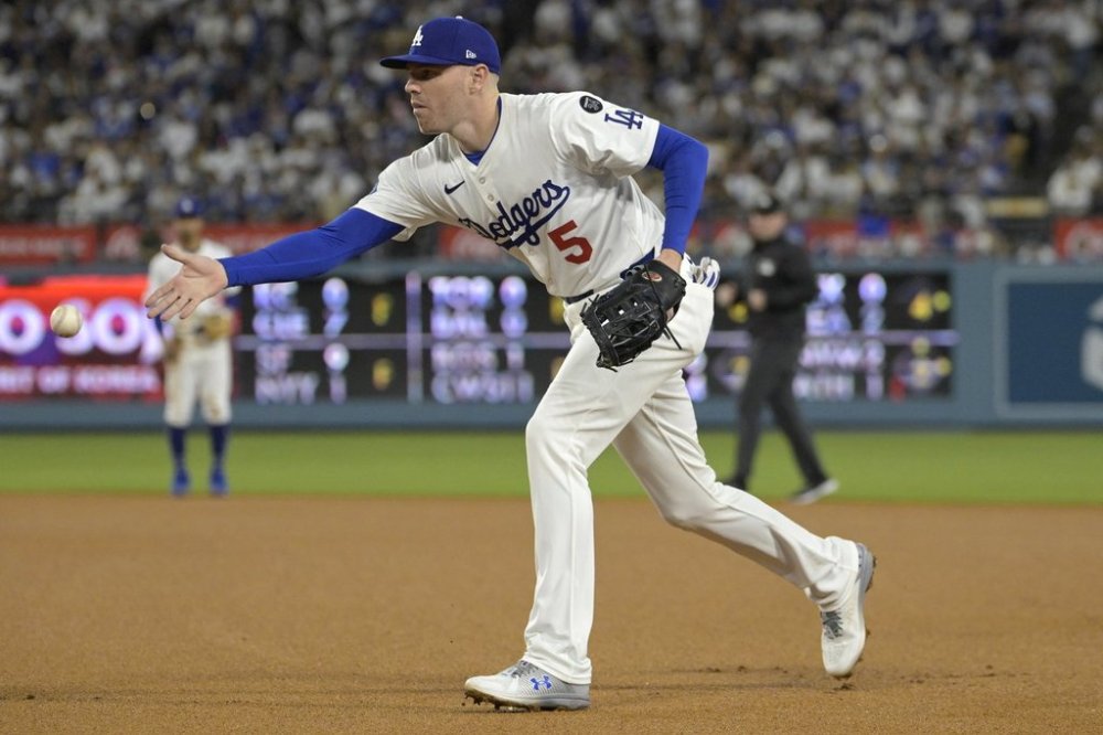 Los Angeles Dodgers first baseman Freddie Freeman tosses the ball to first base for an out in the third inning of a baseball game against the Chicago Cubs, Friday, April 11, 2025, in Los Angeles. (AP Photo/Jayne Kamin-Oncea)