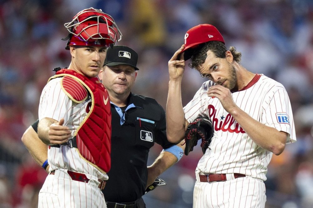Philadelphia Phillies starting pitcher Aaron Nola, right, waits for a new PitchCom as catcher J.T. Realmuto, left, looks on during the fifth inning of a baseball game against the Arizona Diamondbacks, Saturday, May 3, 2025, in Philadelphia. (AP Photo/Chris Szagola)