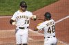 Pittsburgh Pirates' Tommy Pham (28) celebrates with Enmanuel Valdez after both scored on a double by Adam Frazier off Cleveland Guardians pitcher Emmanuel Clase during the ninth inning of a baseball game in Pittsburgh, Sunday, April 20, 2025. (AP Photo/Gene J. Puskar)