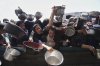 Palestinians struggle to get donated food at a community kitchen in Khan Younis, Gaza Strip, Monday, May 5, 2025. (AP Photo/Abdel Kareem Hana)
