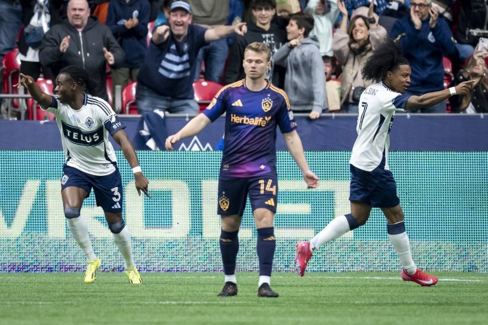 Vancouver Whitecaps' Sam Adekugbe (3) and teammate Jayden Nelson (7) celebrate Adekugbe's goal as Los Angeles Galaxy's John Nelson (14) walks away during the first half of an MLS soccer match in Vancouver, B.C., Sunday, March 2, 2025. THE CANADIAN PRESS/Ethan Cairns