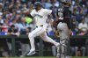 Seattle Mariners' Jorge Polanco scores on a sacrifice fly by Luke Raley as Miami Marlins catcher Agustín Ramírez looks to the outfield during the second inning of a baseball game Saturday, April 26, 2025, in Seattle. (AP Photo/Lindsey Wasson)