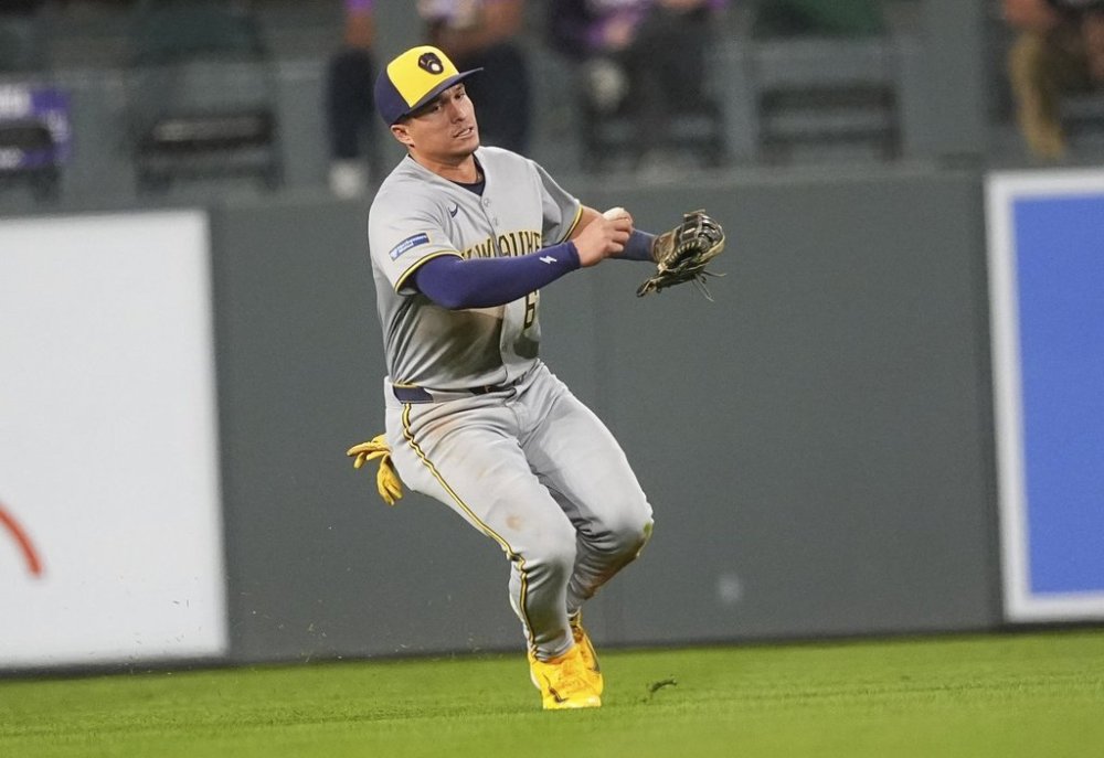 Milwaukee Brewers left fielder Isaac Collins pulls in a shallow fly ball off the bat of Colorado Rockies' Ryan McMahon to end the fifth inning of a baseball game Tuesday, April 8, 2025, in Denver. (AP Photo/David Zalubowski)