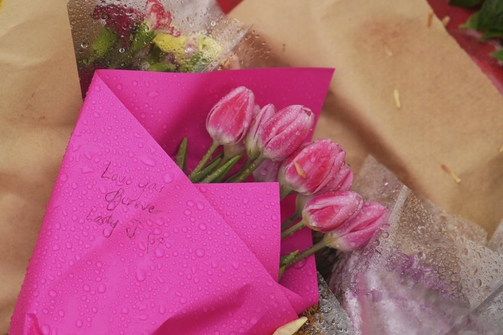 Flowers drenched in rain sit at a memorial next to the scene where a driver killed multiple people last week during a Filipino community festival Tuesday, April 29, 2025, in Vancouver, British Columbia. (AP Photo/Lindsey Wasson)