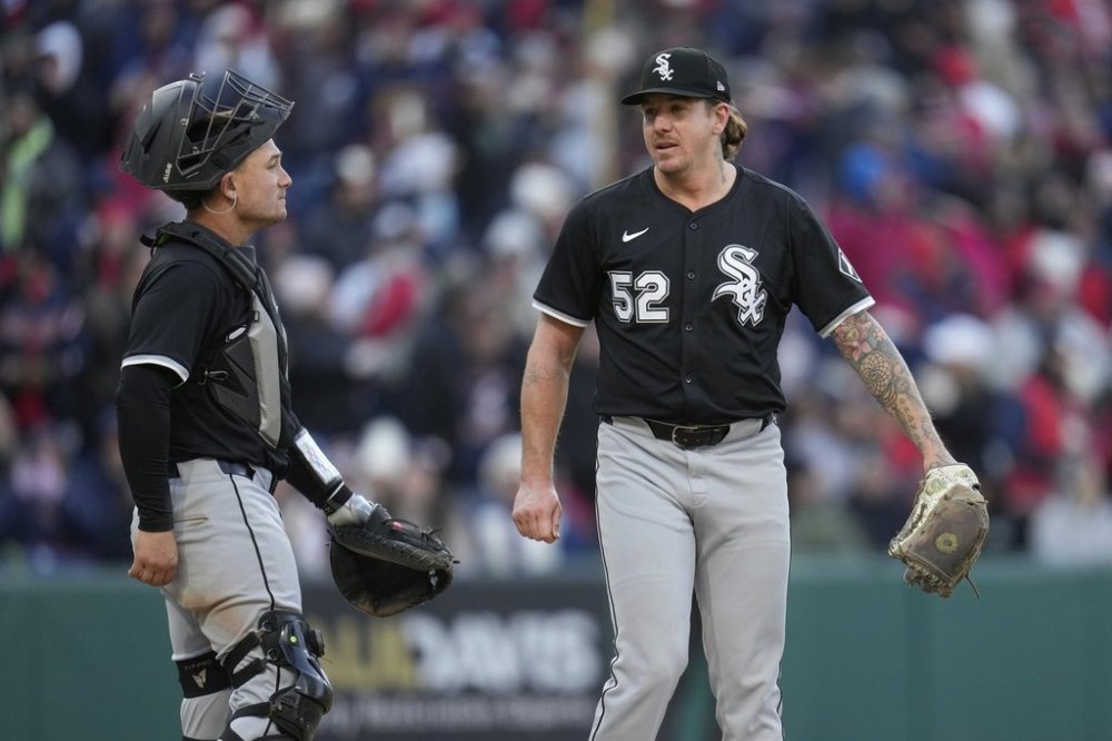 Chicago White Sox catcher Matt Thaiss, left, walks out to the mound to talk with pitcher Mike Clevinger, right, in the ninth inning of a baseball game against the Cleveland Guardians in Cleveland, Tuesday, April 8, 2025. (AP Photo/Sue Ogrocki)