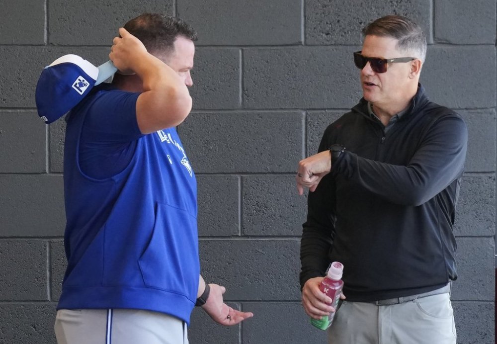 Toronto Blue Jays manager John Schneider, left, talks with Blue Jays general manager Ross Atkins, right, as players work out during spring training in Dunedin Fla., on Friday, February 14, 2025. THE CANADIAN PRESS/Nathan Denette