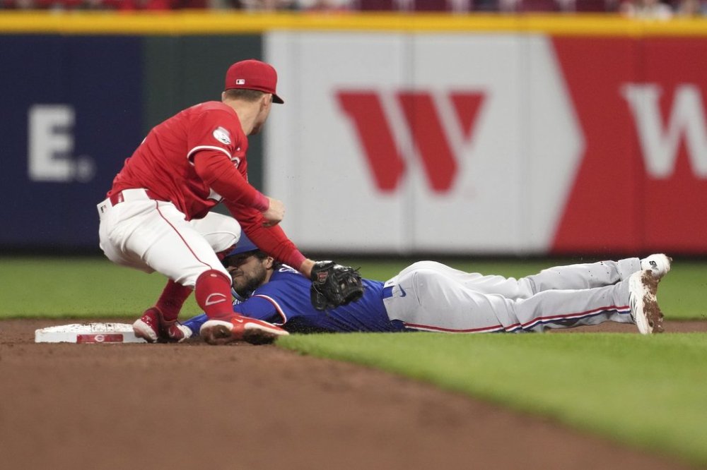 Texas Rangers' Josh Smith steals second base before Cincinnati Reds' Matt McLain can apply the tag in the ninth inning of a baseball game Tuesday, April 1, 2025, in Cincinnati. (AP Photo/Kareem Elgazzar)