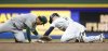 Milwaukee Brewers' Brice Turang, right, steals second base as the Athletics' Luis Urias applies the late tag during the second inning of a baseball game, Sunday, April 20, 2025, in Milwaukee. (AP Photo/Jeffrey Phelps)