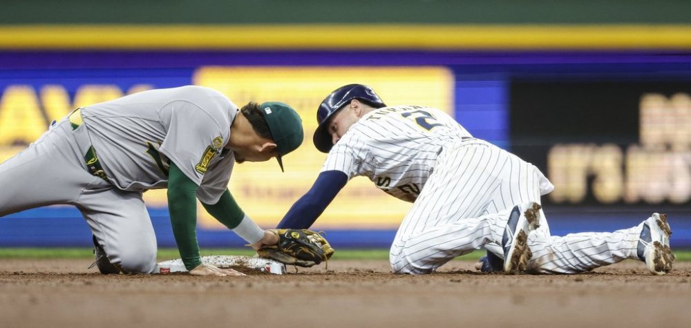 Milwaukee Brewers' Brice Turang, right, steals second base as the Athletics' Luis Urias applies the late tag during the second inning of a baseball game, Sunday, April 20, 2025, in Milwaukee. (AP Photo/Jeffrey Phelps)