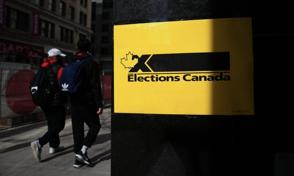 People walk past an Elections Canada sign outside an office in Montreal, Tuesday, April 15, 2025. THE CANADIAN PRESS/Sean Kilpatrick