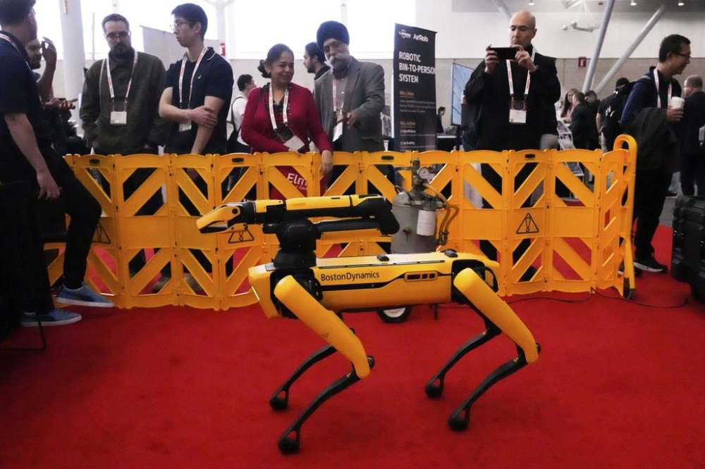 Convention guests watch as a Boston Dynamics robot is demontrated at the Robotics Summit & Expo, Wednesday, April 30, 2025, in Boston. (AP Photo/Charles Krupa)