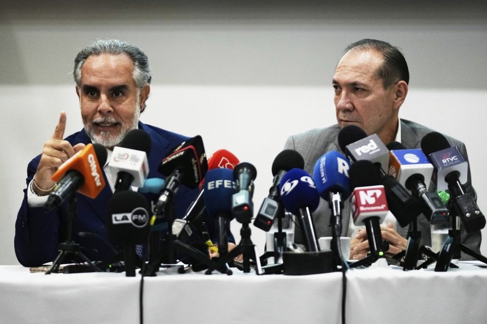Colombian Interior Minister Armando Benedetti, left, and Labor Minister Antonio Sanguino hold a press conference about a proposed referendum on labor reform in Bogota, Colombia, Tuesday, April 22, 2025. (AP Photo/Fernando Vergara)