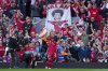 Liverpool's Mohamed Salah takes a selfie with a fans smartphone as he celebrates after scoring his side's fourth goal during the English Premier League soccer match between Liverpool and Tottenham Hotspur at Anfield in Liverpool, England, Sunday, April 27, 2025. (AP Photo/Jon Super)