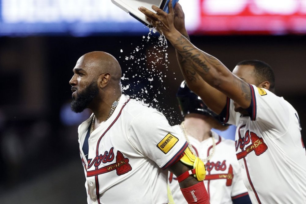 Atlanta Braves designated hitter Marcell Ozuna (left) is doused with water by Raisel Iglesias (right) after hitting a walk off RBI during the10th inning of a baseball game to beat the Cincinnati Reds, Tuesday, May 6, 2025, in Atlanta. (AP Photo/Butch Dill)