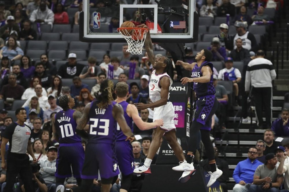 Los Angeles Clippers forward Kawhi Leonard (2) dunks past Sacramento Kings forward Keegan Murray (13) during the first half of an NBA basketball game Friday, April 11, 2025, in Sacramento, Calif. (AP Photo/Scott Marshall)