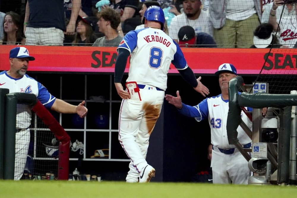 Atlanta Braves' Alex Verdugo (8) is greeted at the dugout by Atlanta Braves manager Brian Snitker (43) after scoring against the Minnesota Twins during the third inning of a baseball game Saturday, April 19, 2025, in Atlanta. (AP Photo/ John David Mercer)