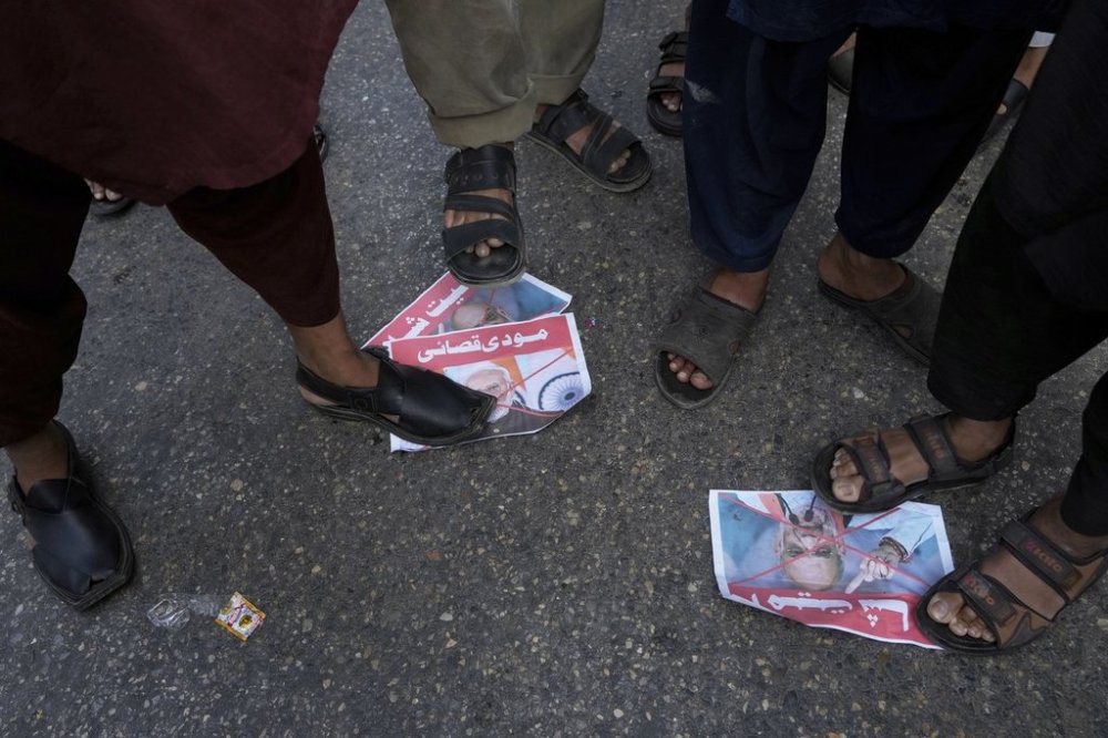 Supporters of the Pakistan Murkazi Muslim League party stand over the crossed posters of Indian Prime Minister Narendra Modi and Indian Minister of Home Affairs Amir Shah during a demonstration against the suspension of water-sharing treaty by India with Pakistan, in Karachi, Pakistan Thursday, April 24, 2025. (AP Photo/Fareed Khan)