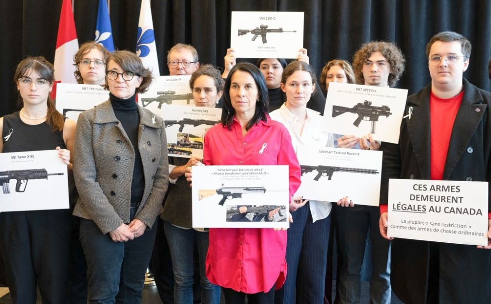 Montreal Mayor Valerie Plante, centre and Nathalie Provost, left, survivor of the 1989 femicide at Ecole polytechnique and spokesperson for PolySeSouvient, a gun-control advocacy organization, hold signs with a student group during a press conference about stricter gun control in Montreal on Tuesday, Nov. 19, 2024. THE CANADIAN PRESS/Christinne Muschi