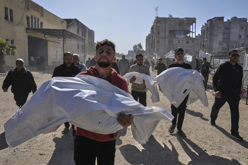 Mourners carry white sacks cover the bodies of members of the Abu Al-Rous family, killed when an Israeli airstrike struck their displacement tent overnight, during their funeral in Khan Younis, southern Gaza Strip, Thursday, April 17, 2025. (AP Photo/Abdel Kareem Hana)