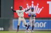 Minnesota Twins' Byron Buxton (25), left, celebrates next to New York Mets shortstop Francisco Lindor (12) after hitting an RBI-single during the fifth inning of a baseball game, Wednesday, April 16, 2025, in Minneapolis. (AP Photo/Abbie Parr)