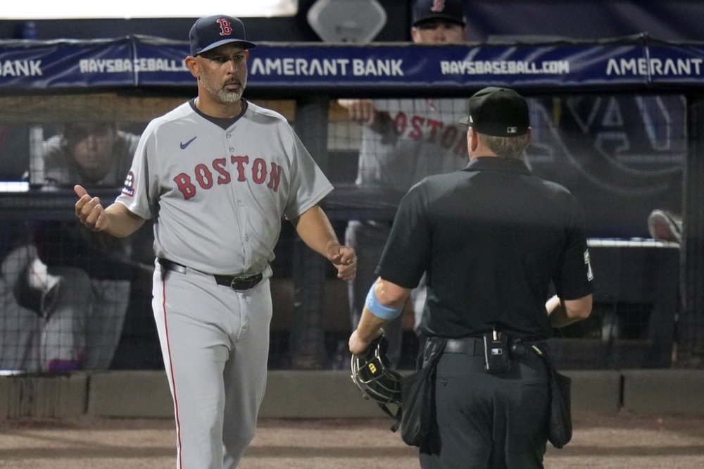 Boston Red Sox manager Alex Cora talks to home plate umpire Mike Muchlinski after a foul ball by Trevor Story off Tampa Bay Rays pitcher Shane Baz during the fourth inning of a baseball game Monday, April 14, 2025, in Tampa, Fla. (AP Photo/Chris O'Meara)
