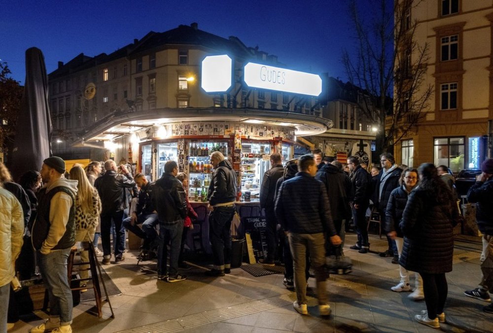People gather at a former water house, a small shop that sprung up in the 19th century to encourage workers to drink affordable water rather than beer or schnapps, that is now a kiosk in Frankfurt, Germany, on March 8, 2025. (AP Photo/Michael Probst)
