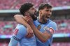 Manchester City's Josko Gvardiol, left, and Ruben Dias celebrate after a goal during the English FA Cup semifinal soccer match between Nottingham Forest and Manchester City at Wembley stadium in London, Sunday, April 27, 2025. (AP Photo/Kirsty Wigglesworth)