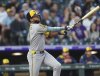 Milwaukee Brewers' Jackson Chourio follows the flight of his double to drive in two runs against Colorado Rockies starting pitcher Antonio Senzatela in the third inning of a baseball game Wednesday, April 9, 2025, in Denver. (AP Photo/David Zalubowski)