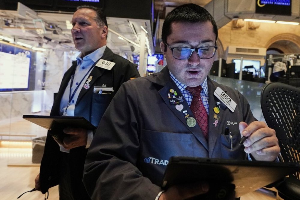 Trader Drew Cohen, right, works on the floor of the New York Stock Exchange, Friday, April 11, 2025. (AP Photo/Richard Drew)
