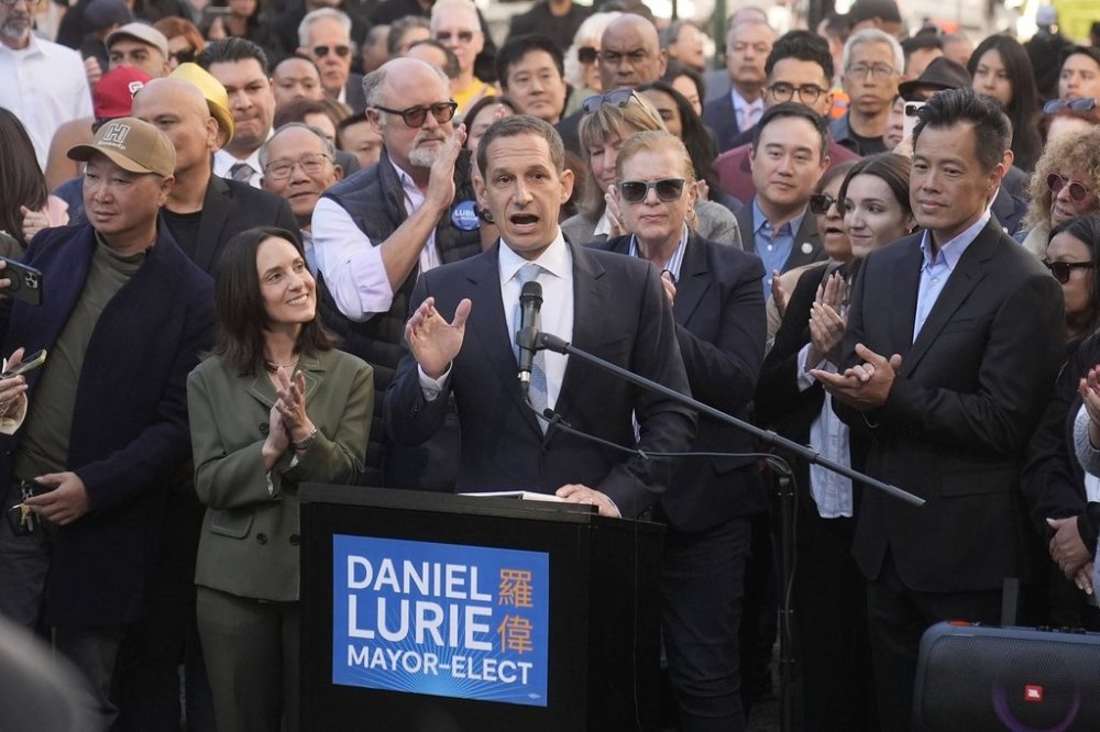 FILE - Daniel Lurie, middle, speaks at a news conference next to his wife, Becca Prowda, middle left, in San Francisco, Friday, Nov. 8, 2024. (AP Photo/Jeff Chiu, File)
