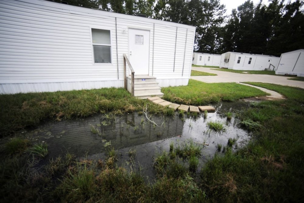 FILE - Fetid water pools outside a mobile home in a small mobile home park in rural Hayneville, Ala., Lowndes County, Aug. 1, 2022. (AP Photo/Jay Reeves, File)